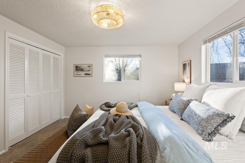 Bedroom featuring carpet floors, a closet, and a textured ceiling