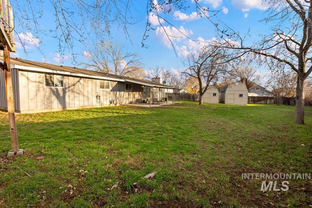 Fenced backyard with a patio and an outbuilding