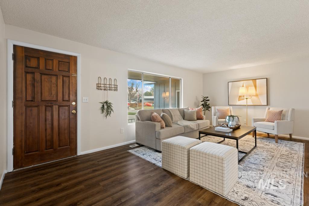 Living room with a textured ceiling and wood finished floors