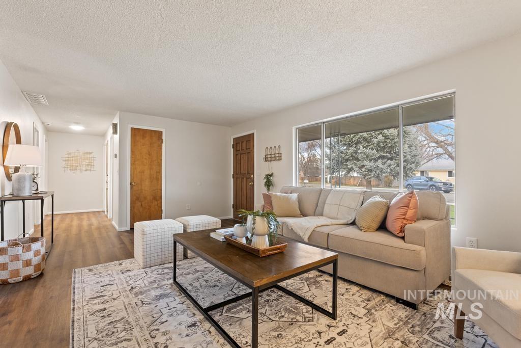 Living room with a textured ceiling and wood finished floors
