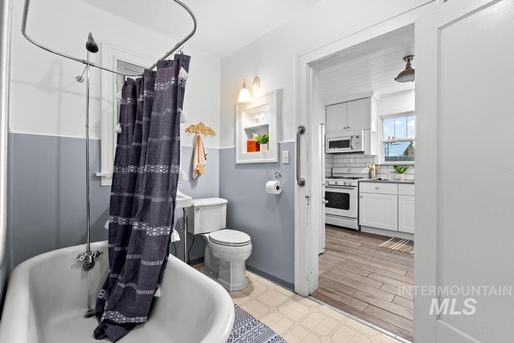Full bathroom with backsplash and light flooring