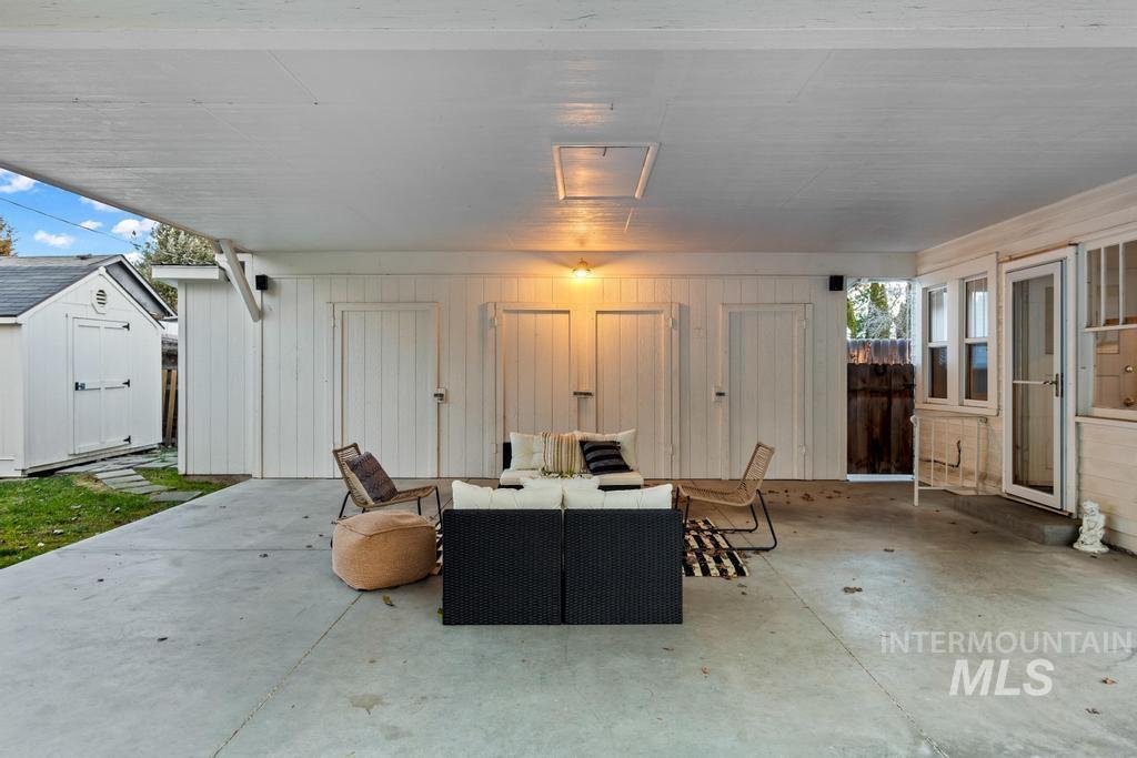 View of patio with outdoor lounge area and a shed