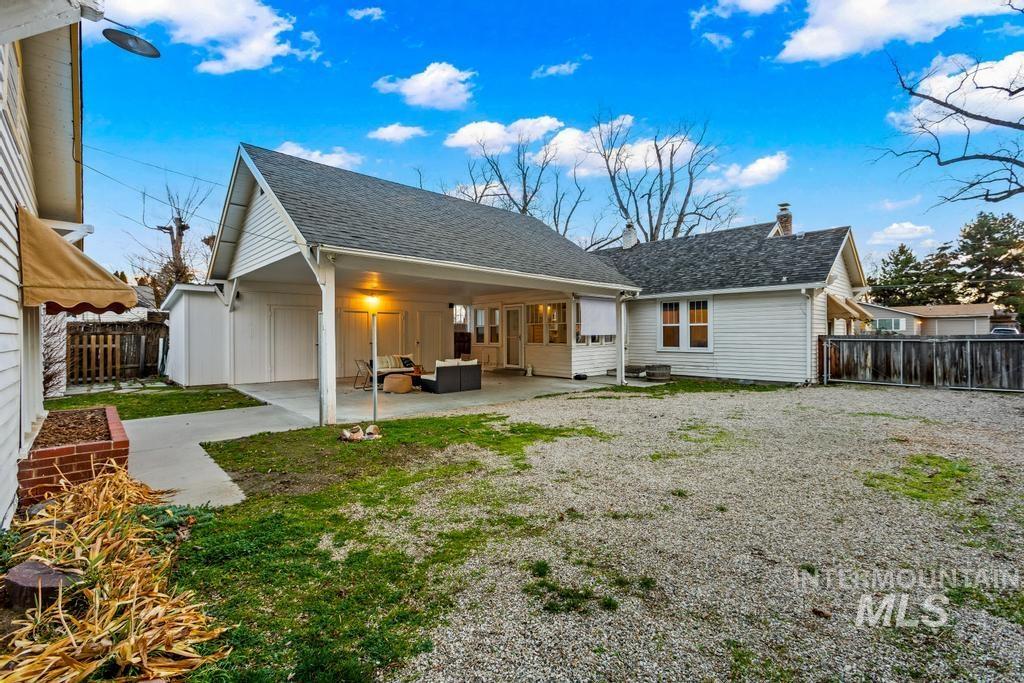 Back of house featuring a patio, a fenced backyard, a shingled roof, a chimney, and board and batten siding