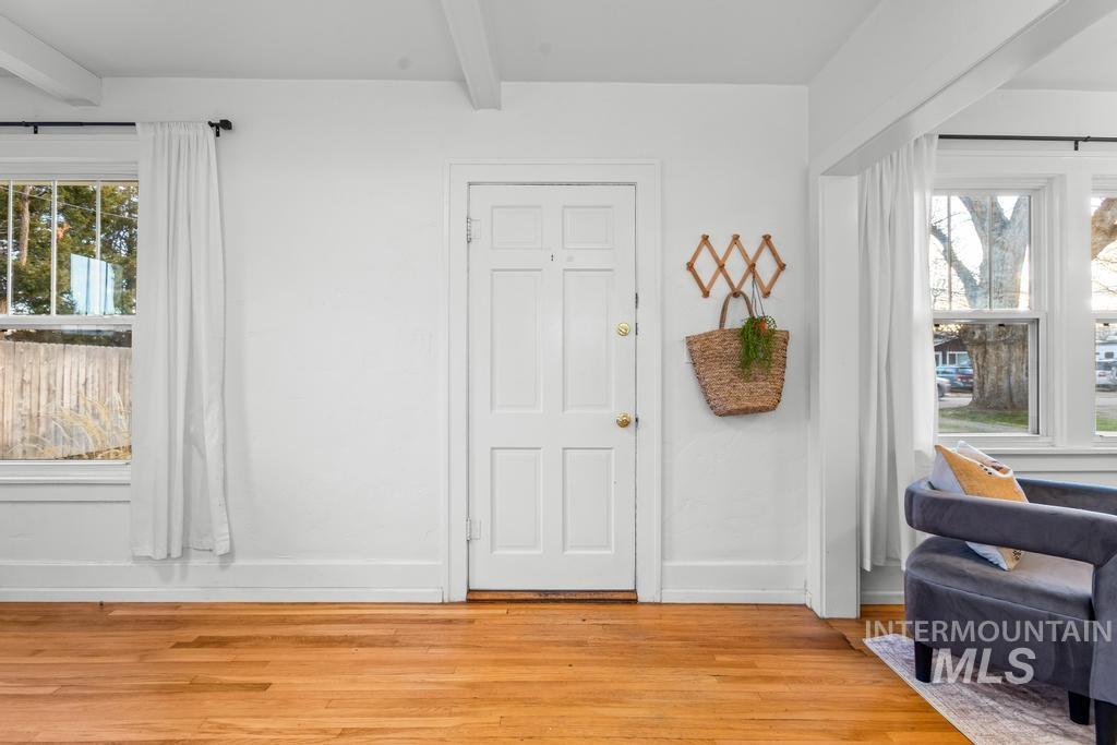Foyer entrance featuring beam ceiling and light wood-type flooring