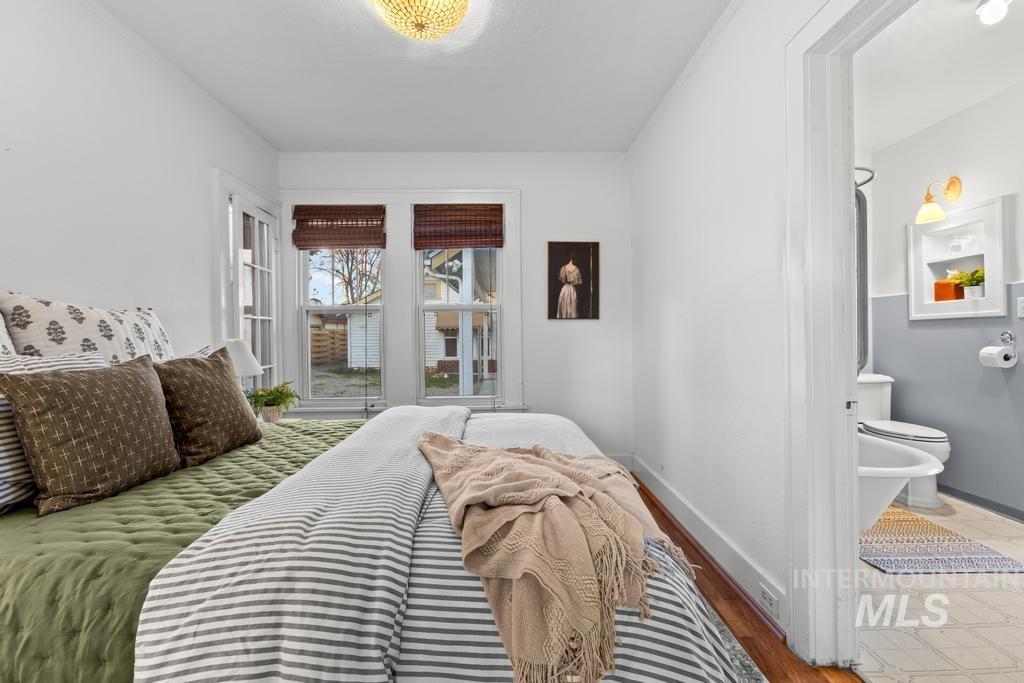 Bedroom featuring wood finished floors and ensuite bath