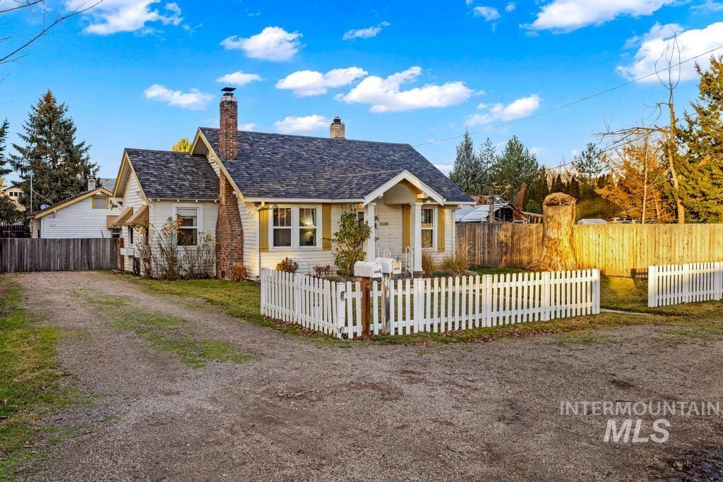 View of front facade featuring a fenced front yard and a chimney
