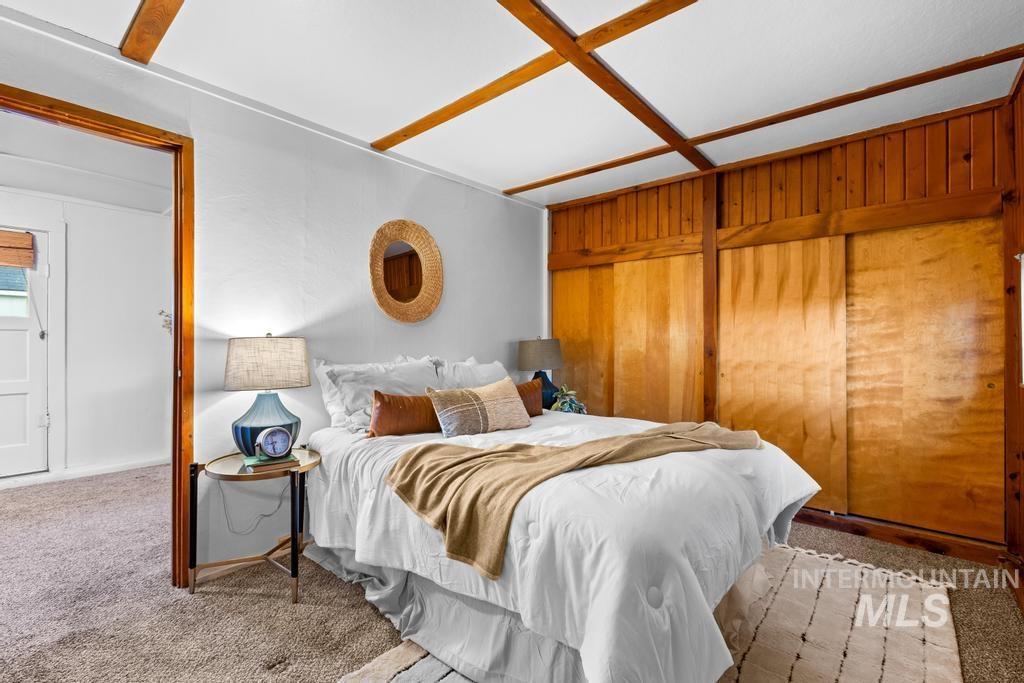 Carpeted bedroom with wood walls