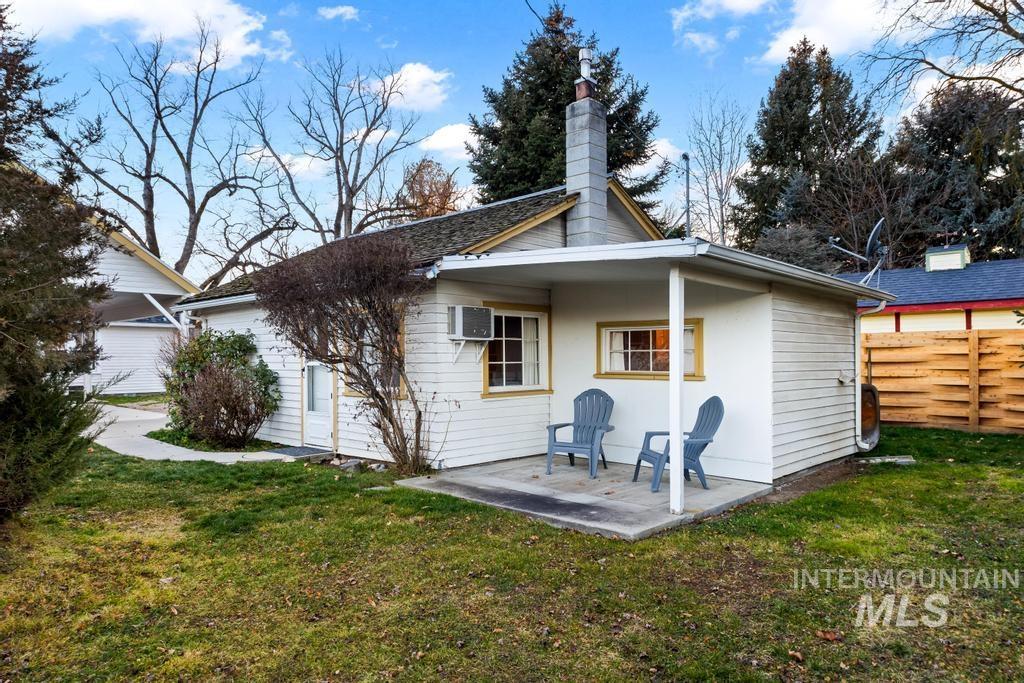 Back of house featuring a chimney, a wall mounted air conditioner, and a patio area