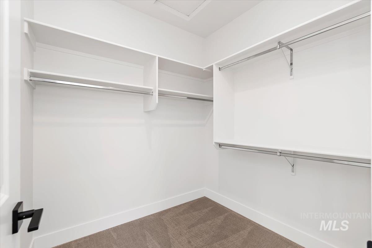 Walk in closet with dark carpet