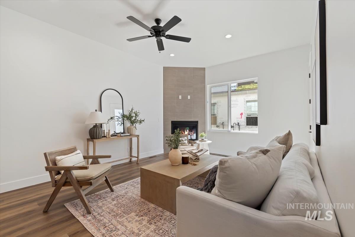 Living room featuring wood finished floors, a fireplace, recessed lighting, and ceiling fan
