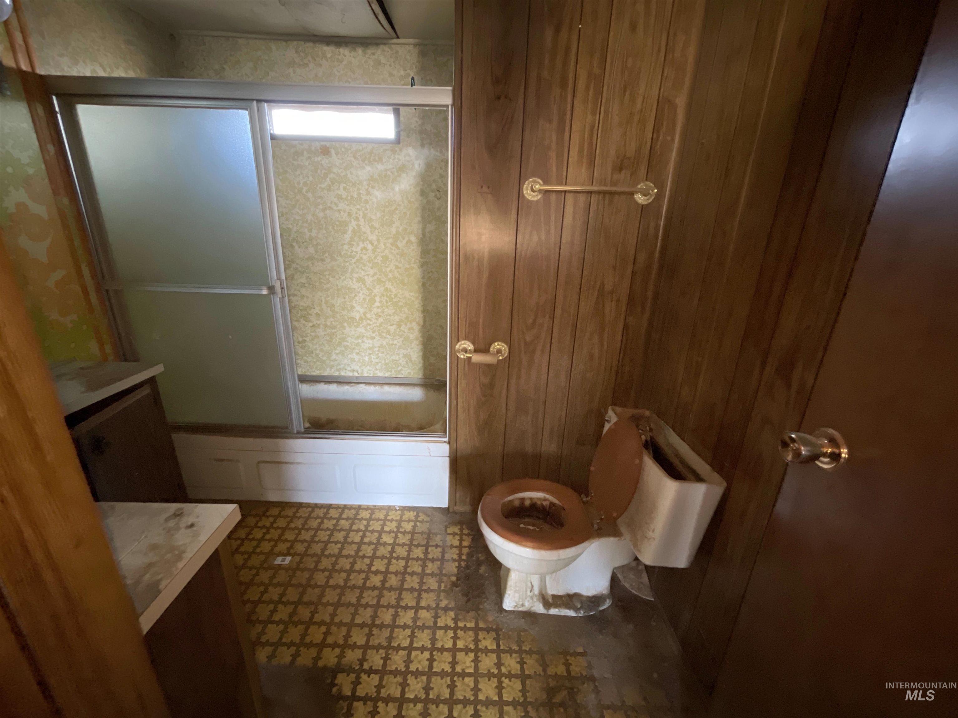 Bathroom featuring combined bath / shower with glass door and vanity