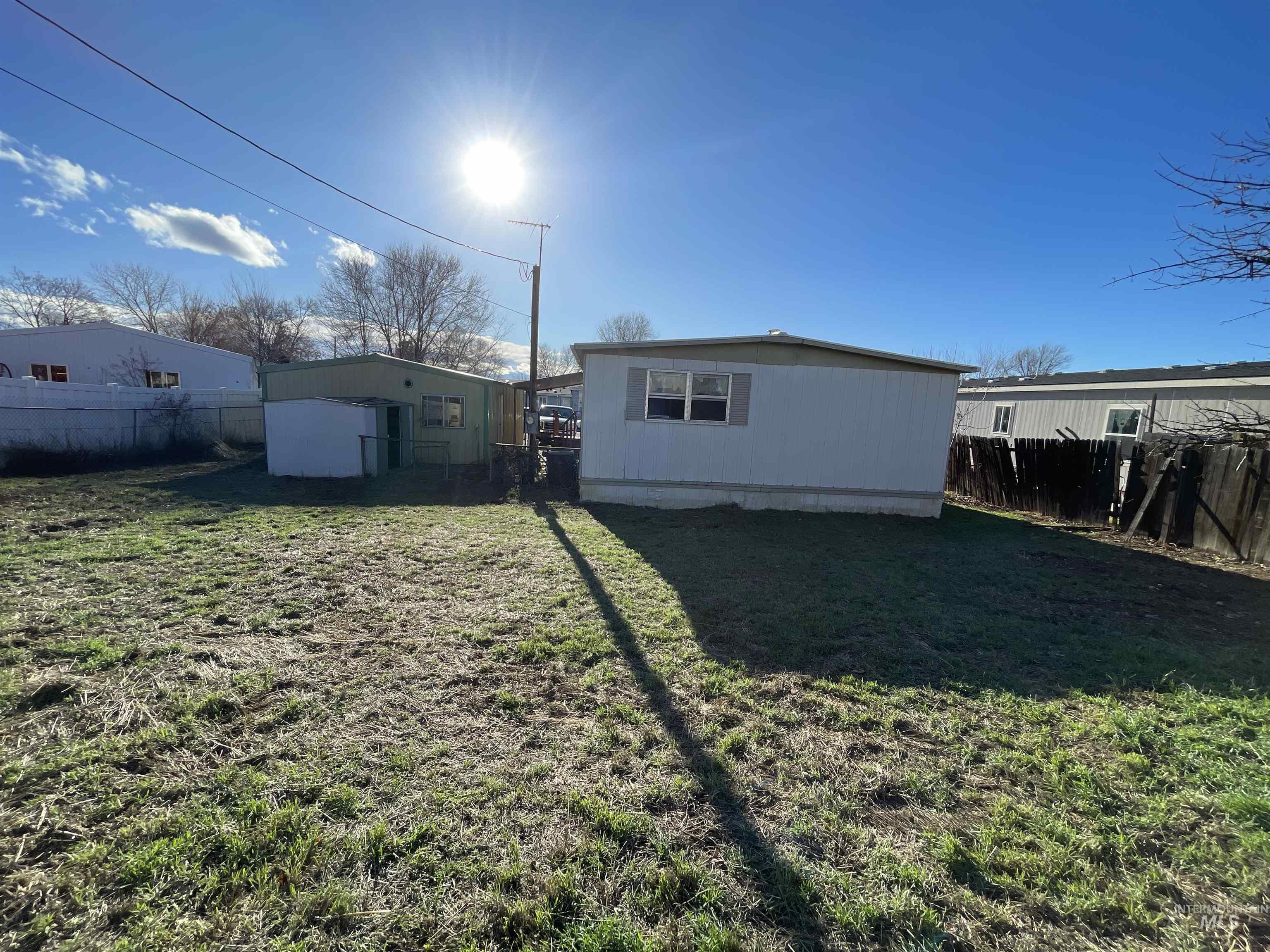 Fenced backyard featuring an outbuilding
