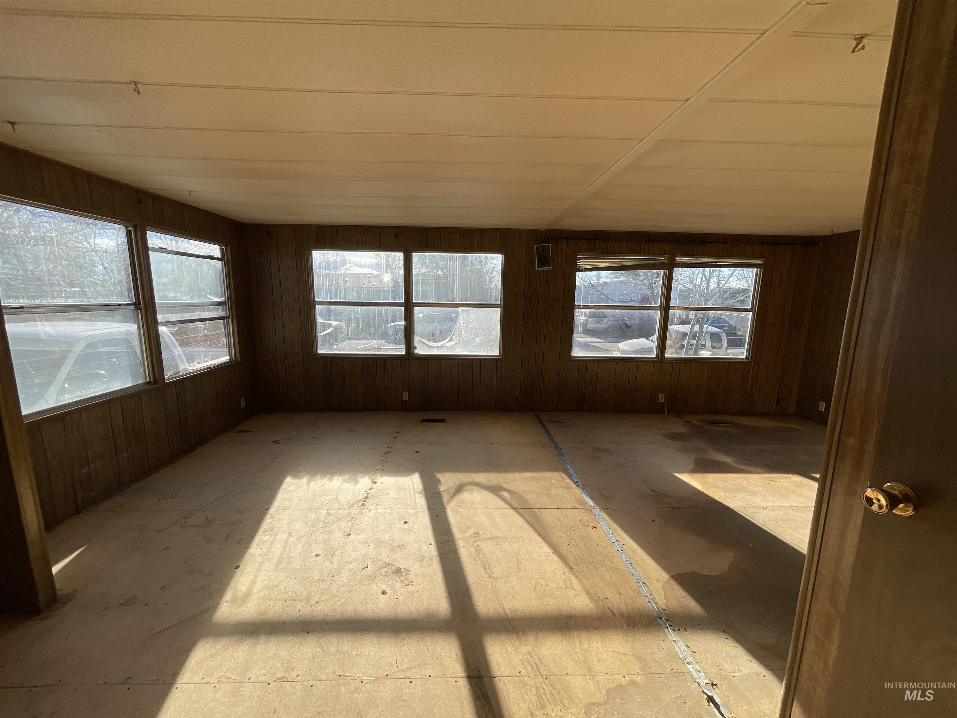 Unfurnished sunroom featuring wood walls
