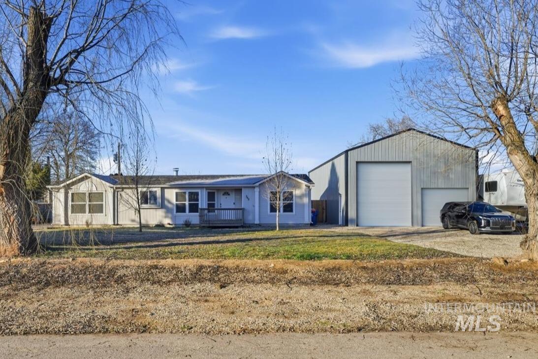 Single story home with an outbuilding, a garage, a front lawn, and covered porch
