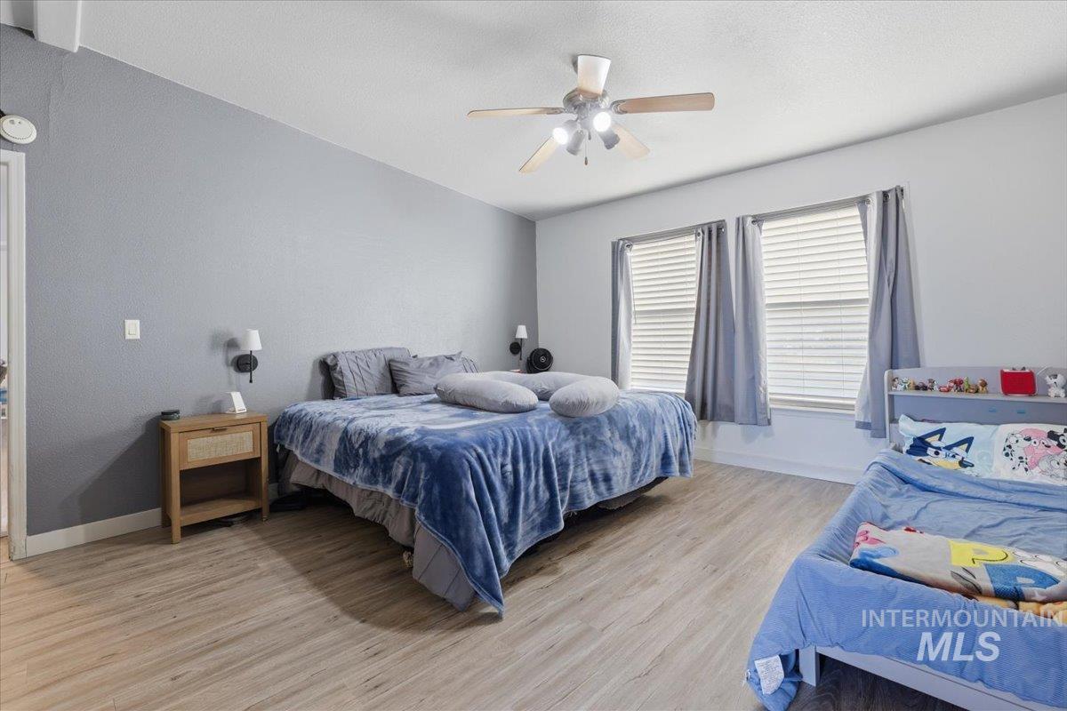 Bedroom with a ceiling fan and light wood-type flooring