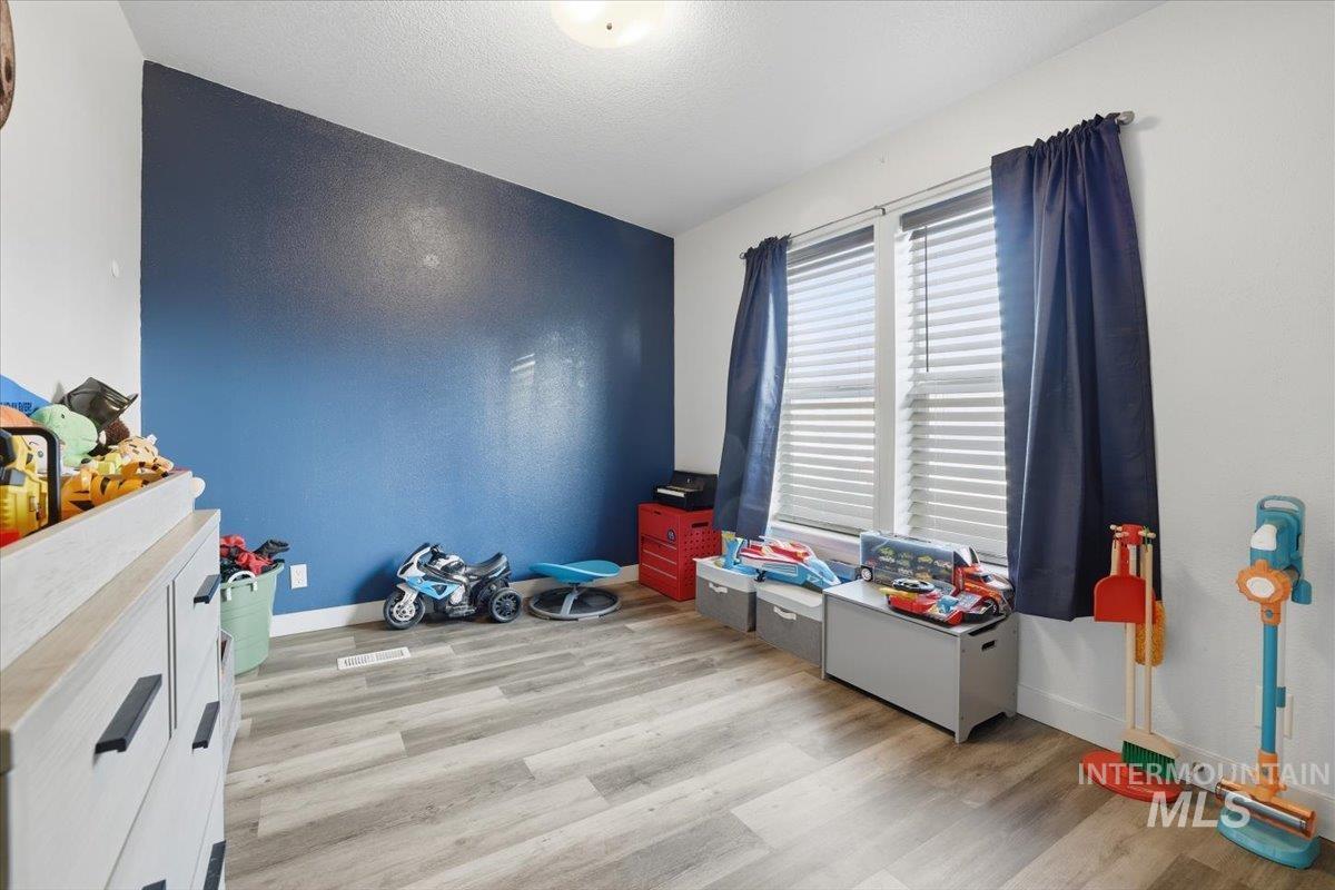 Rec room featuring light wood-style floors and a textured ceiling
