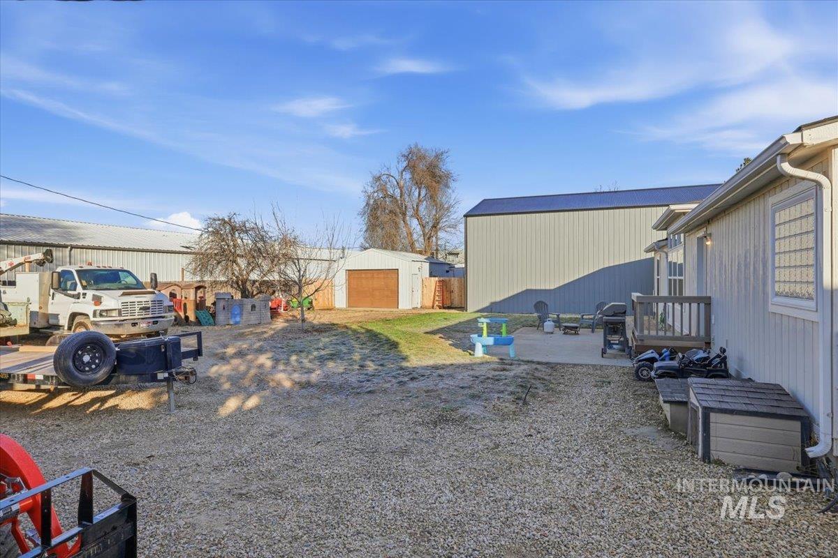 View of yard featuring an outbuilding, a patio, and a detached garage