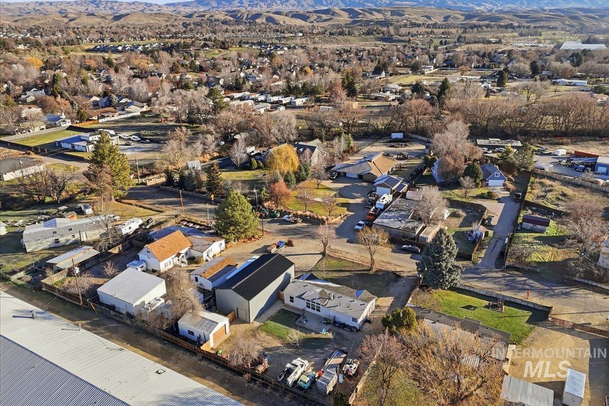 Aerial view of property and surrounding area featuring nearby suburban area