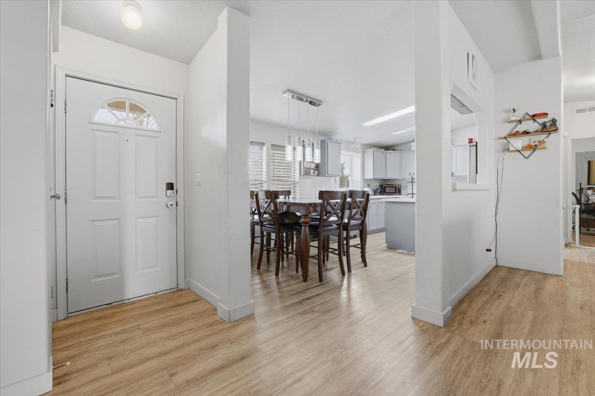 Foyer featuring light wood finished floors and baseboards