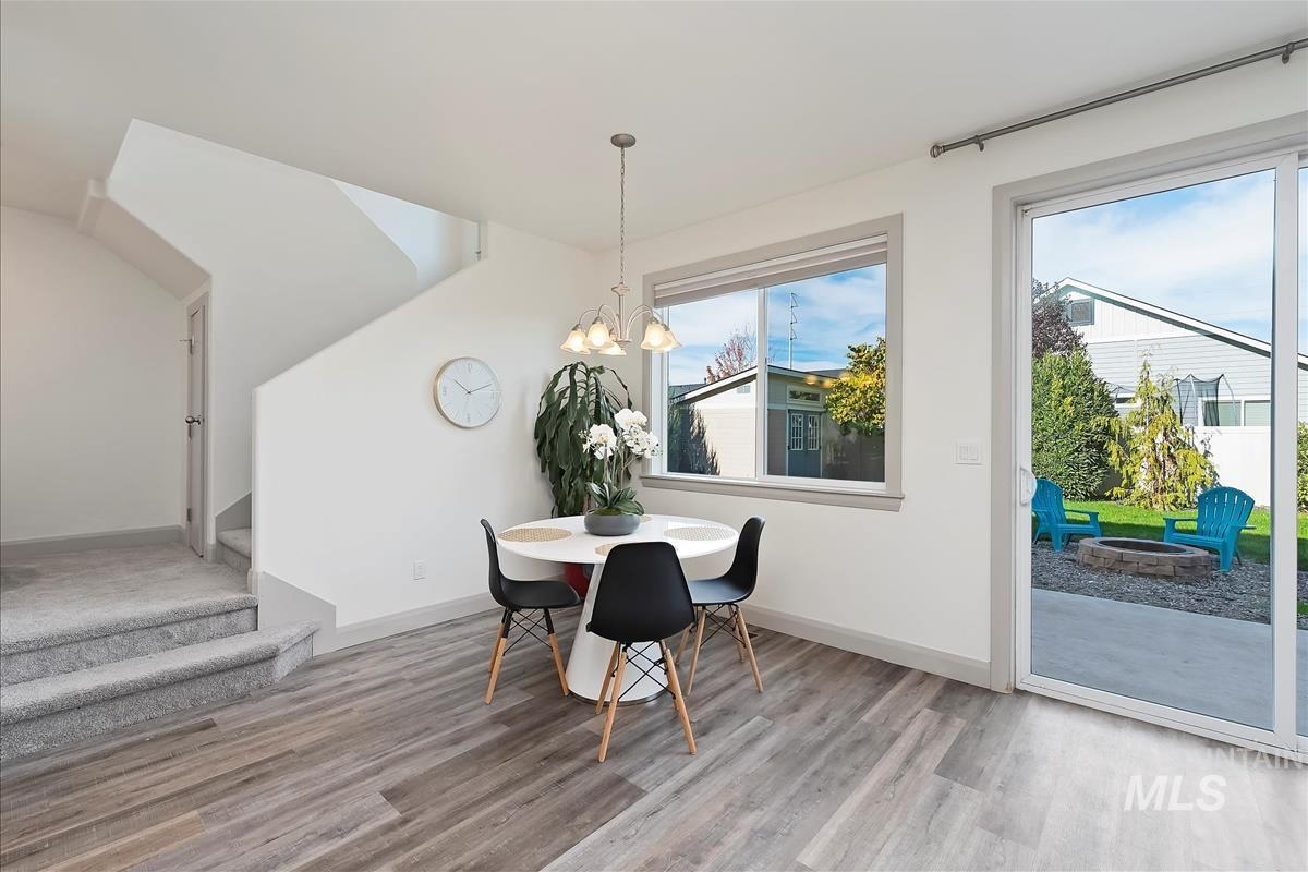 Dining room with a chandelier, stairway, and light wood-style flooring