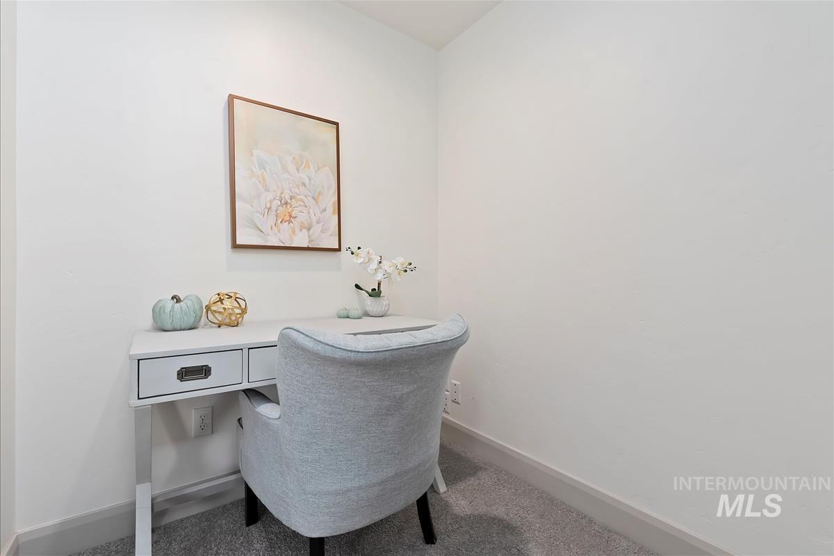 Carpeted home tech space on stair landing with baseboards