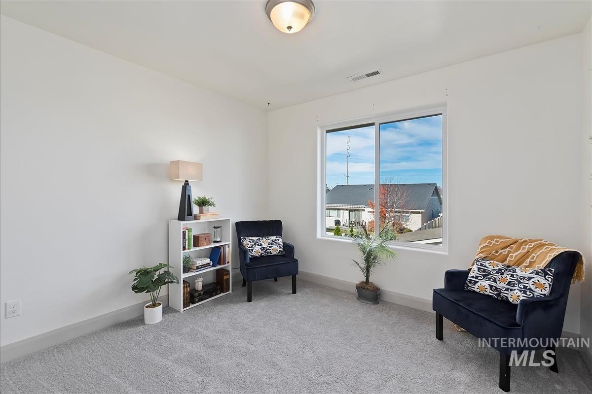 Sitting room featuring carpet floors and baseboards