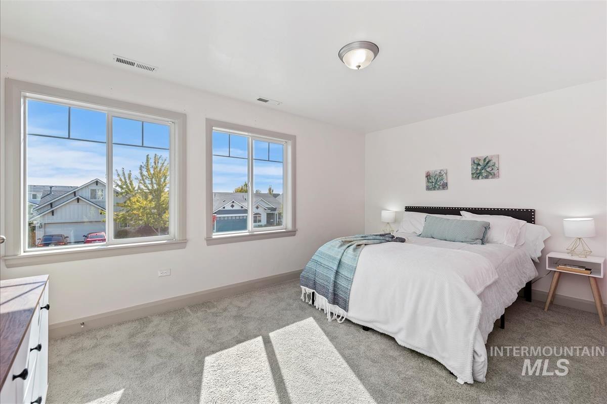 Bedroom featuring light colored carpet and baseboards
