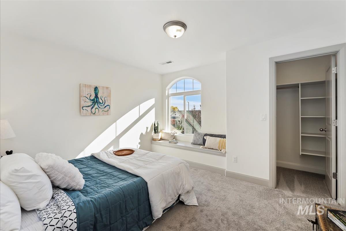 Bedroom with a spacious closet and carpet floors