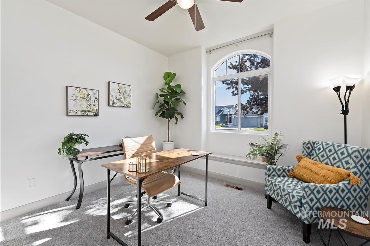 Office with carpet and a ceiling fan