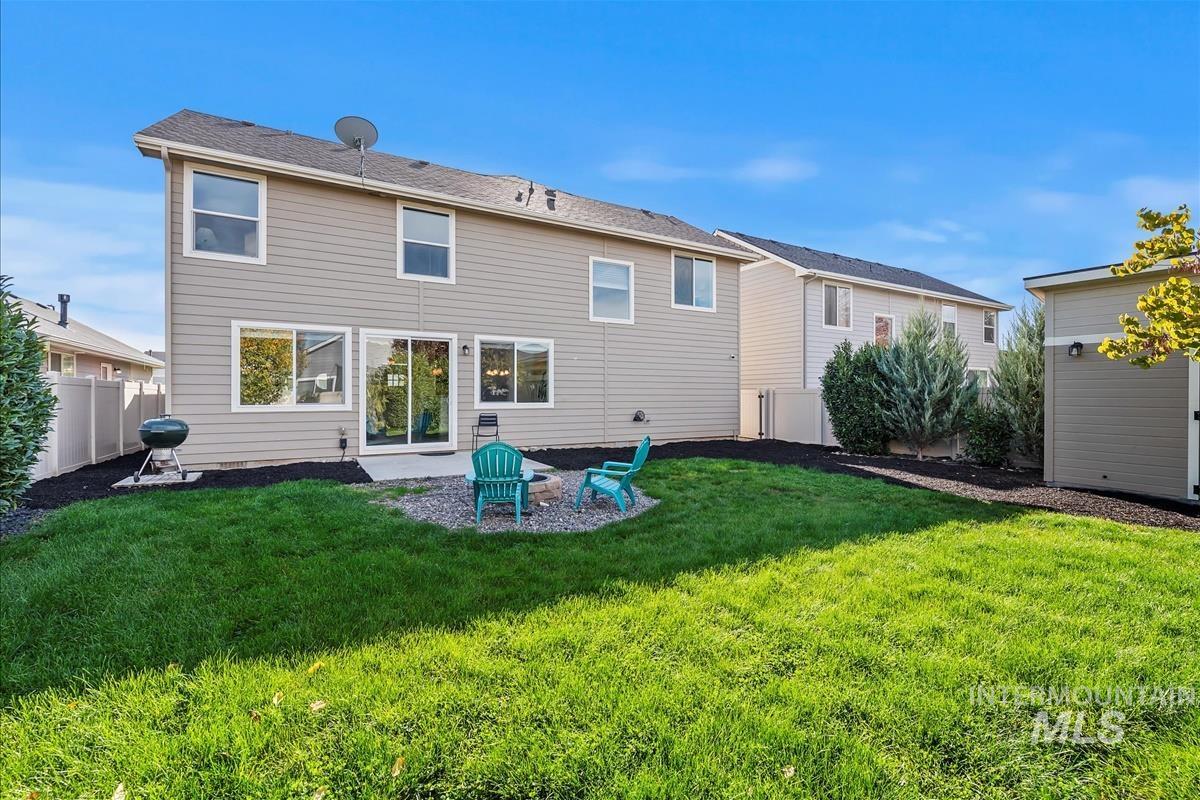 Rear view of house with a fenced backyard and a patio