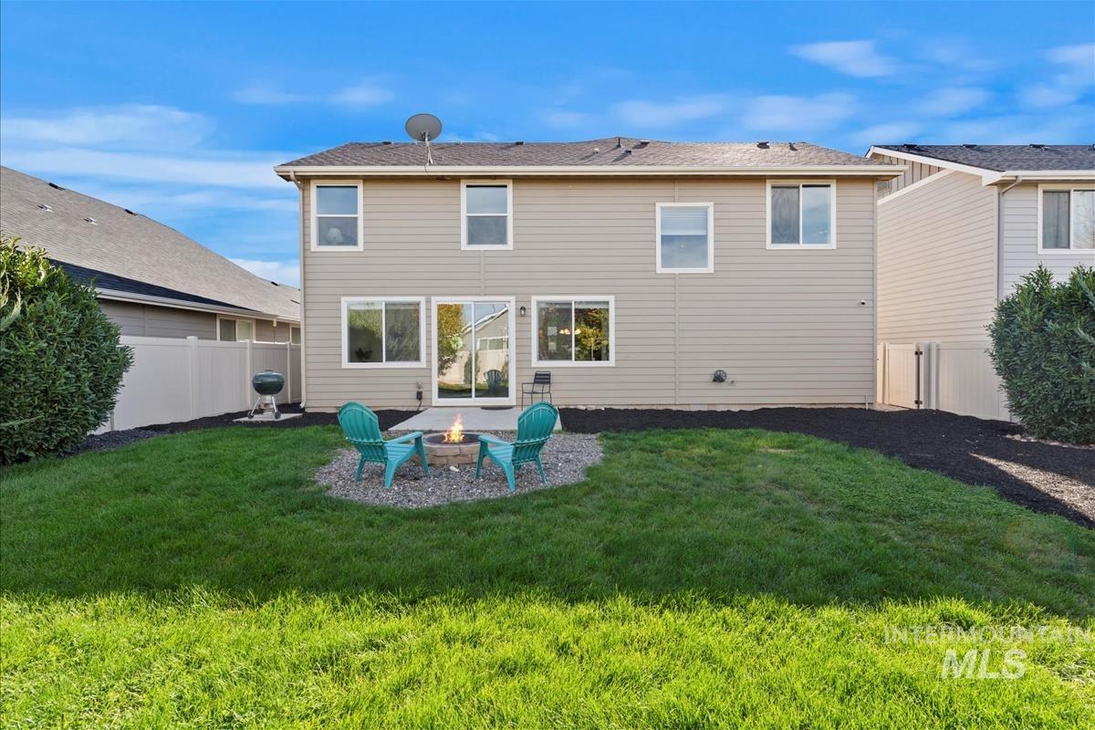 Rear view of property with a patio area, a fire pit, and a fenced backyard