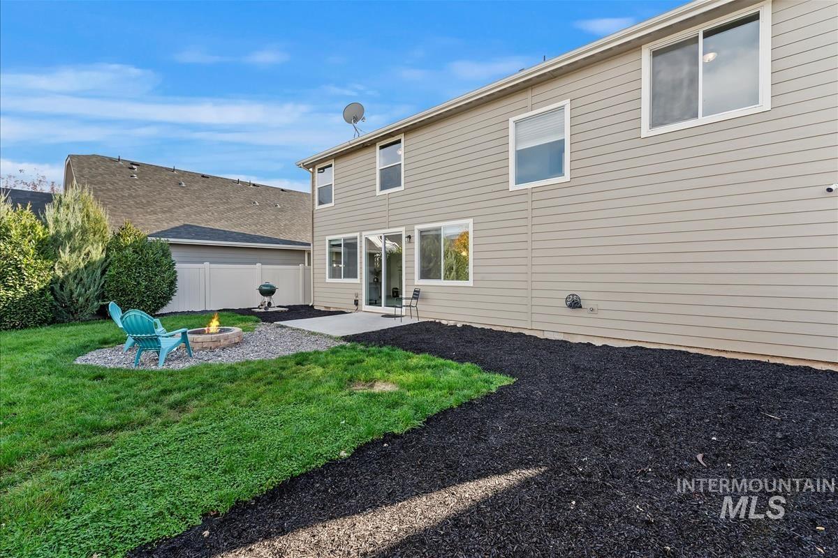 Back of property featuring a patio area and a fire pit