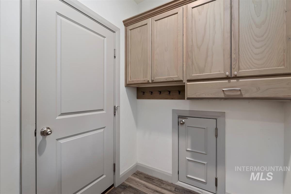 Door between garage and home with discrete dog door into garage to dog run. Mud room has hooks and cabinets.