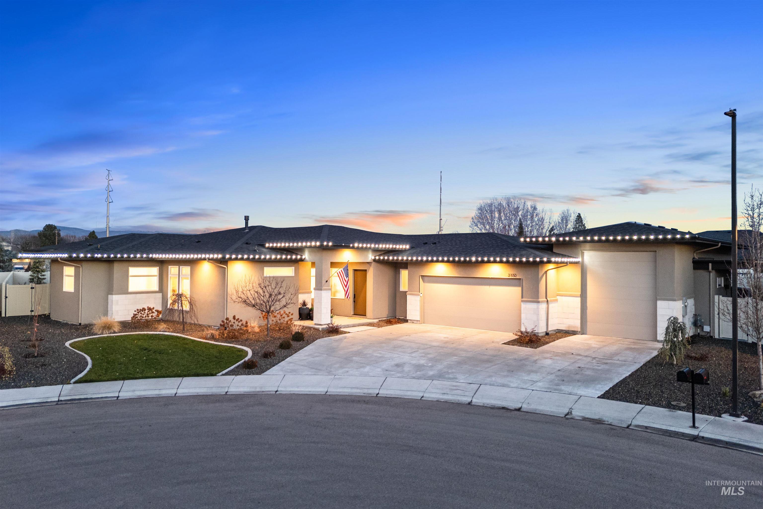 View of front of property featuring an attached garage, driveway, stucco siding, and a tiled roof