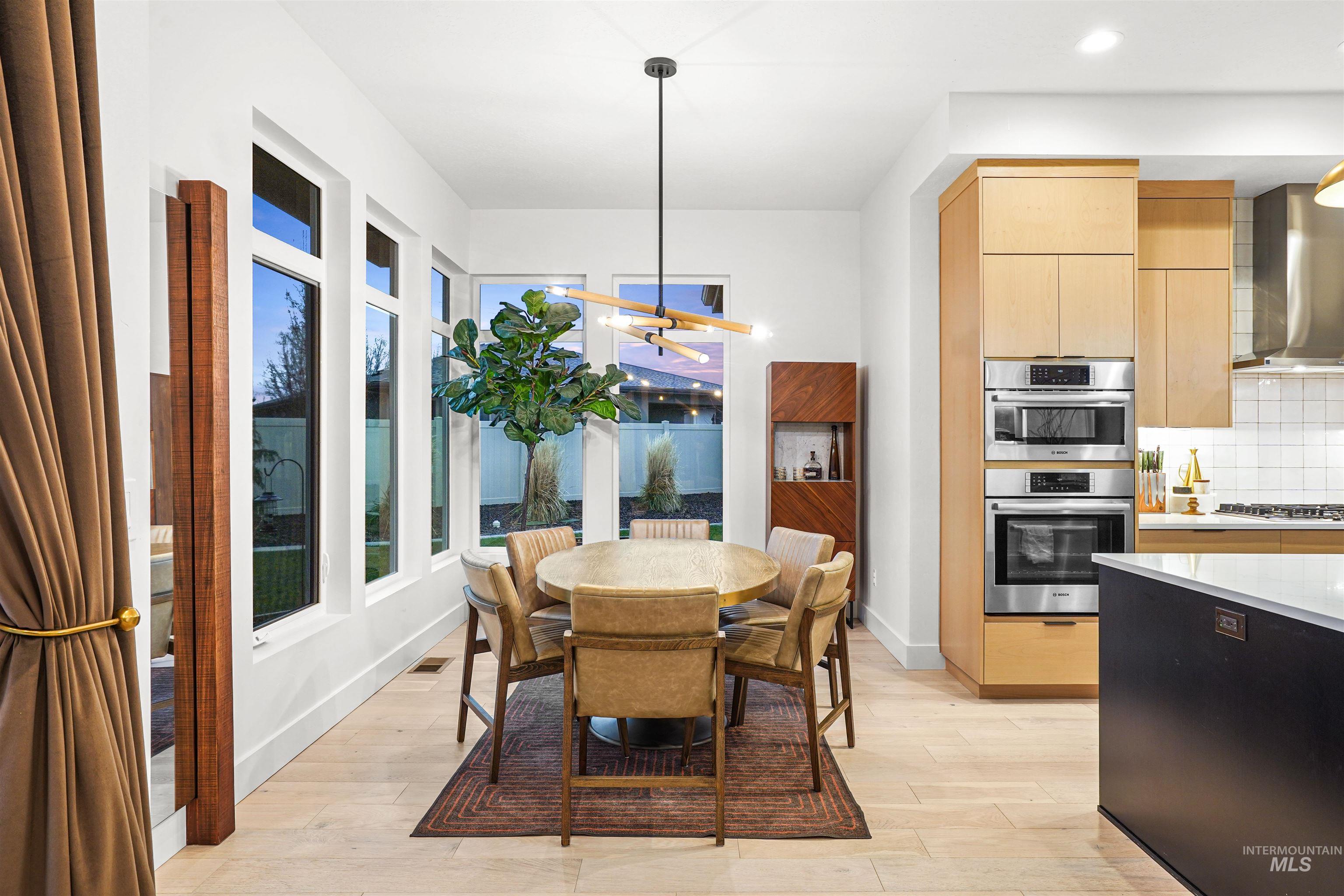 Dining space with light wood-type flooring and a chandelier