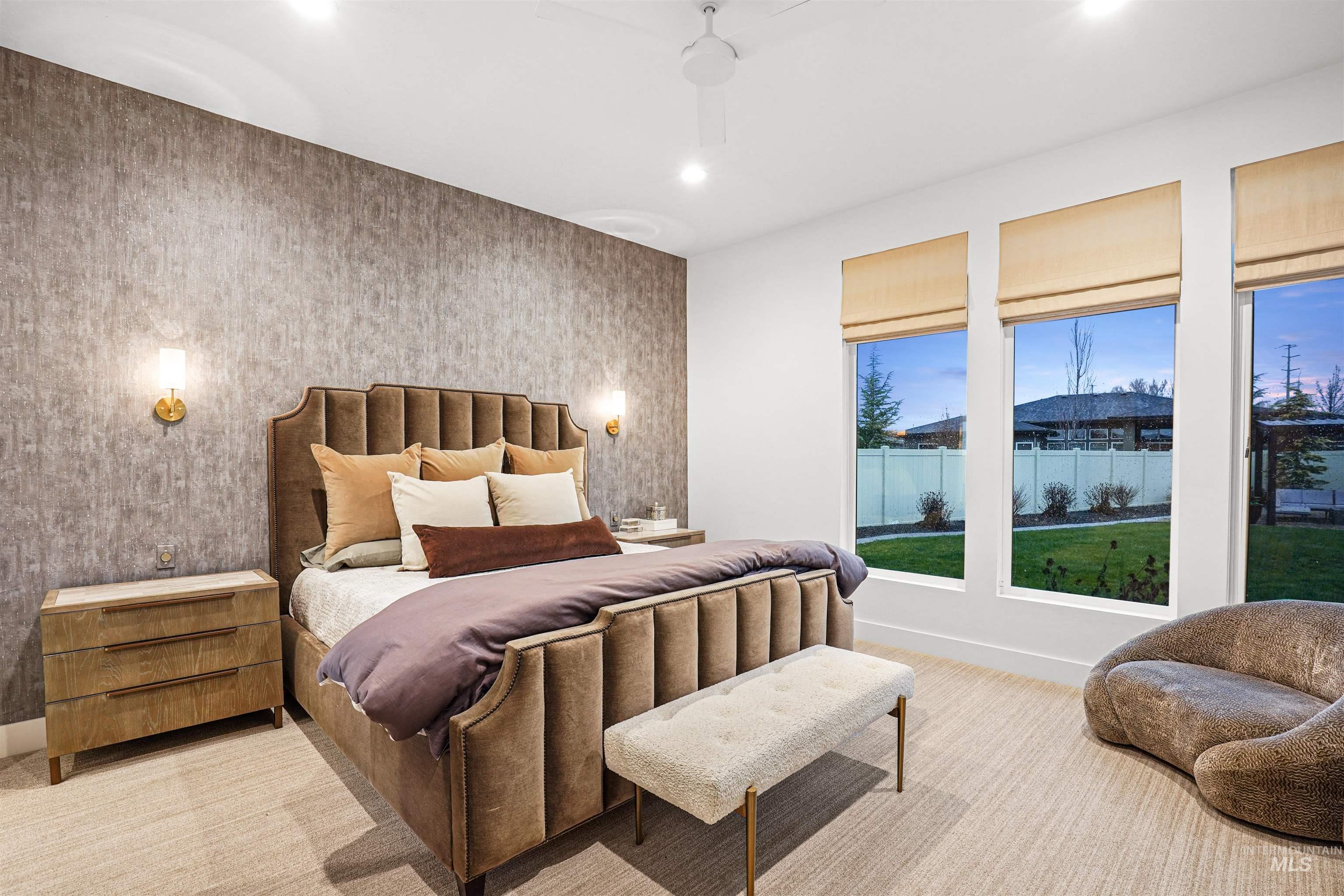 Bedroom with wallpapered walls, recessed lighting, an accent wall, light colored carpet, and ceiling fan