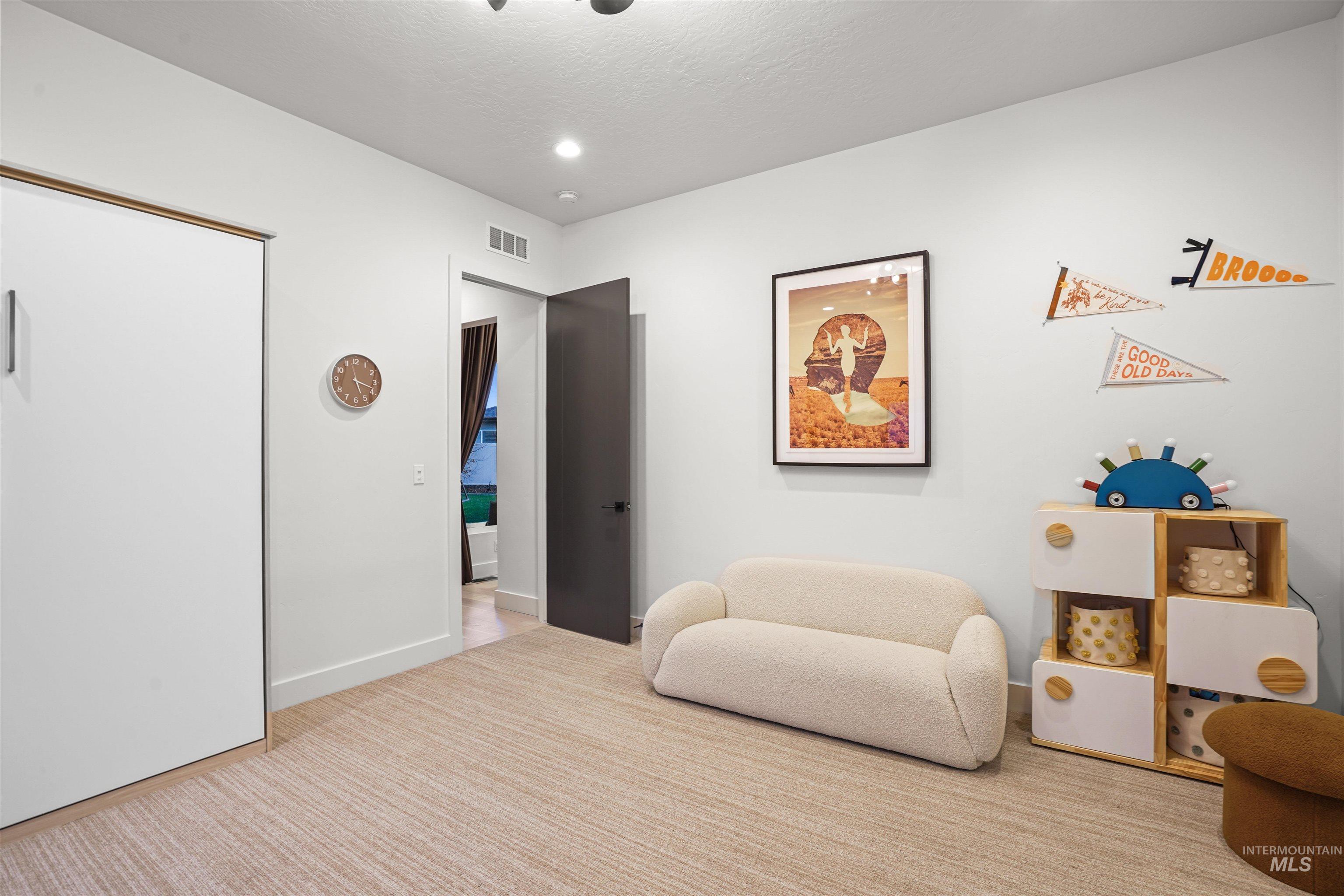 Living area featuring carpet flooring and baseboards