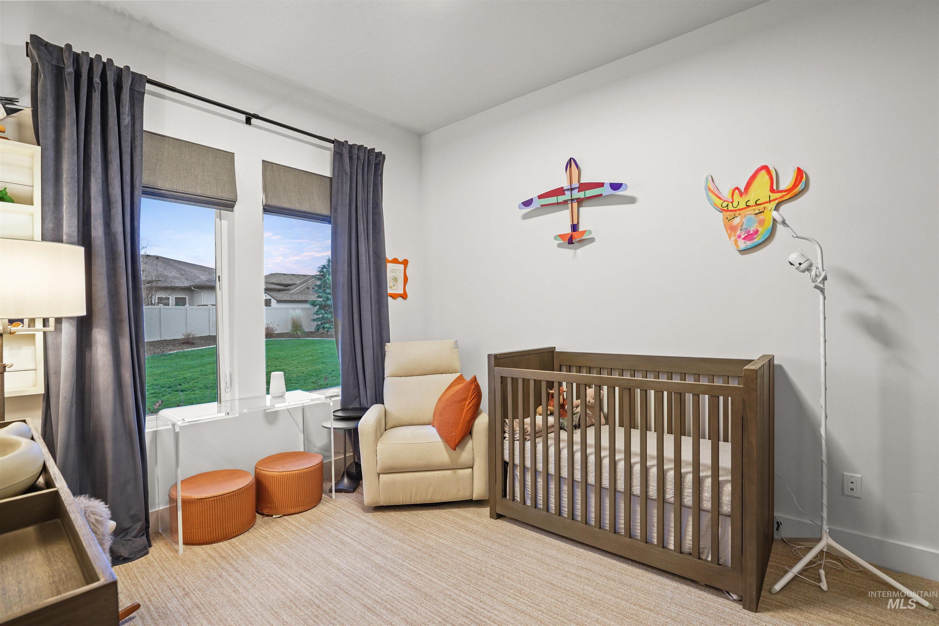 Carpeted bedroom featuring a crib