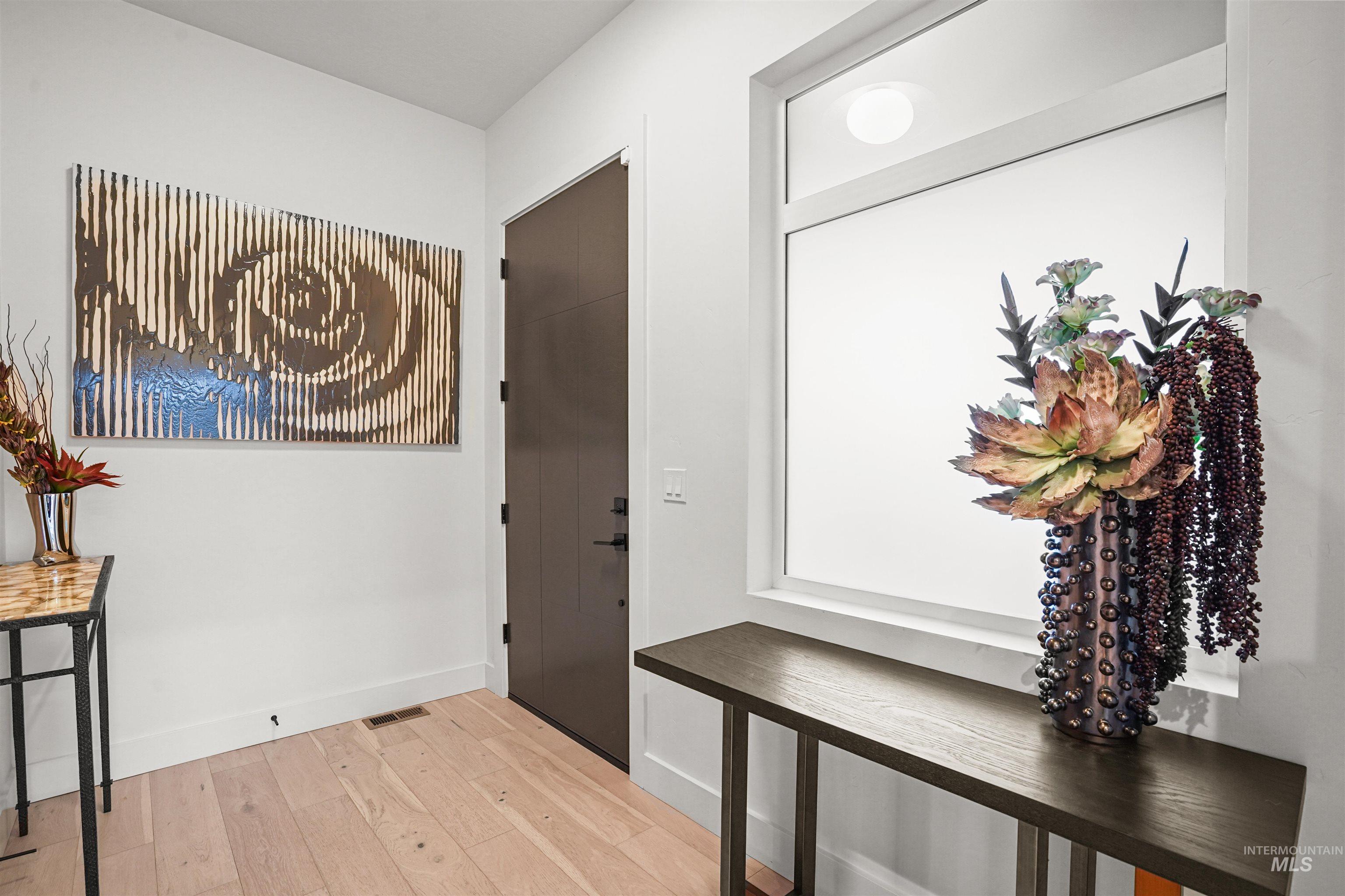 Foyer entrance featuring light wood finished floors and baseboards
