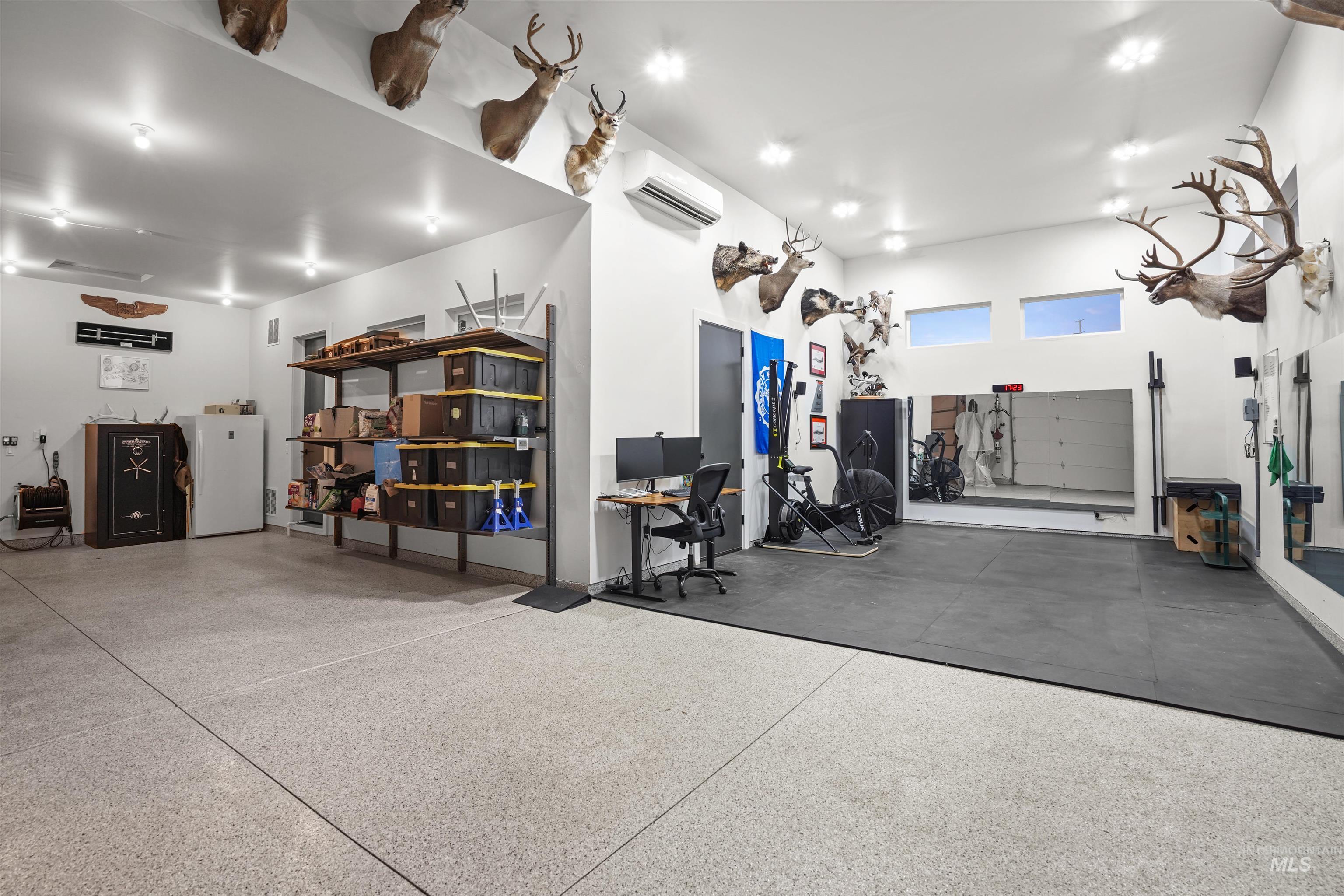 Garage with freestanding refrigerator and a wall unit AC