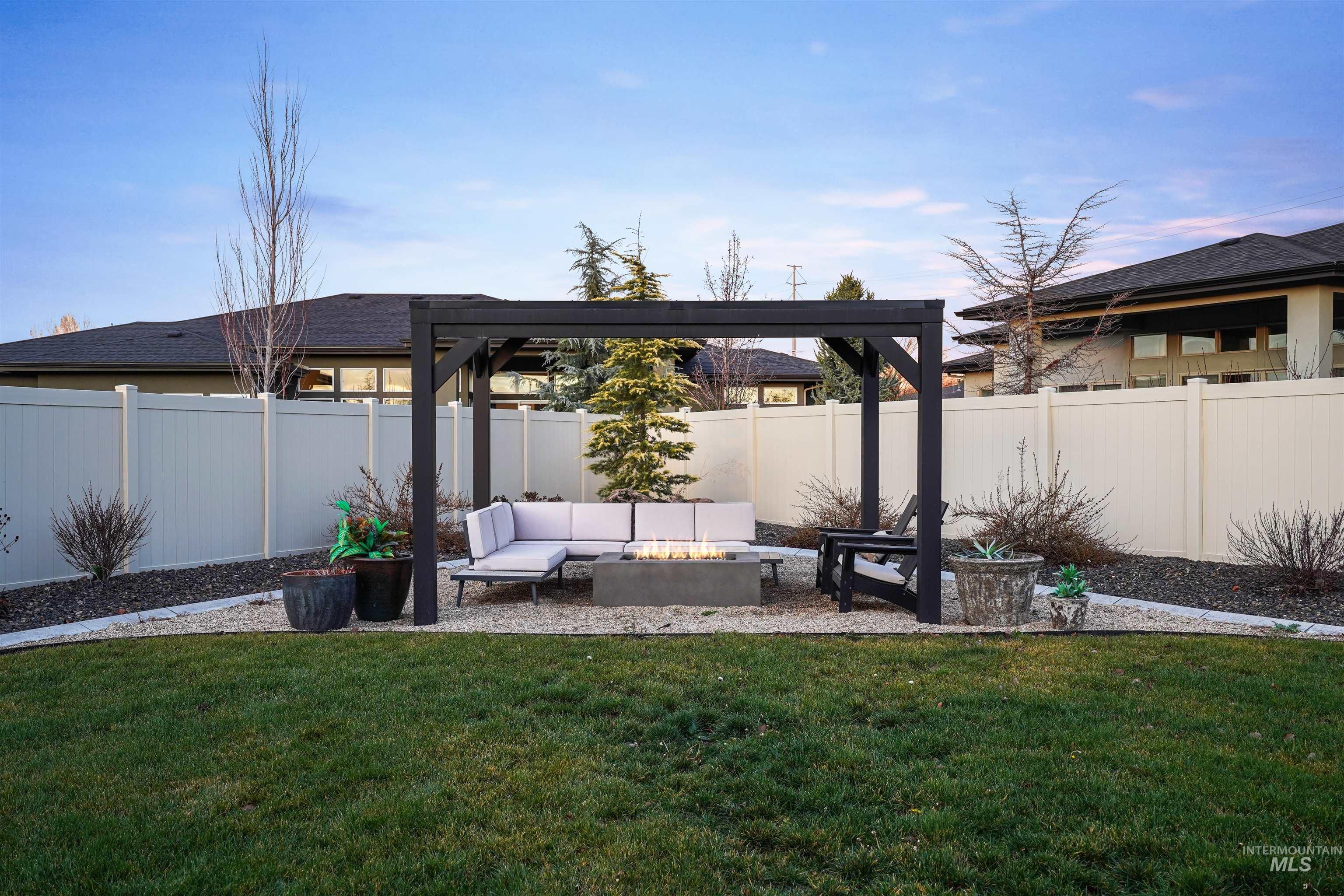 Fenced backyard with an outdoor living space with a fire pit and a patio area