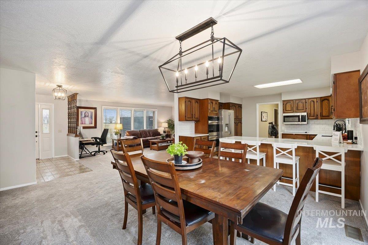 Dining space with a chandelier and light carpet