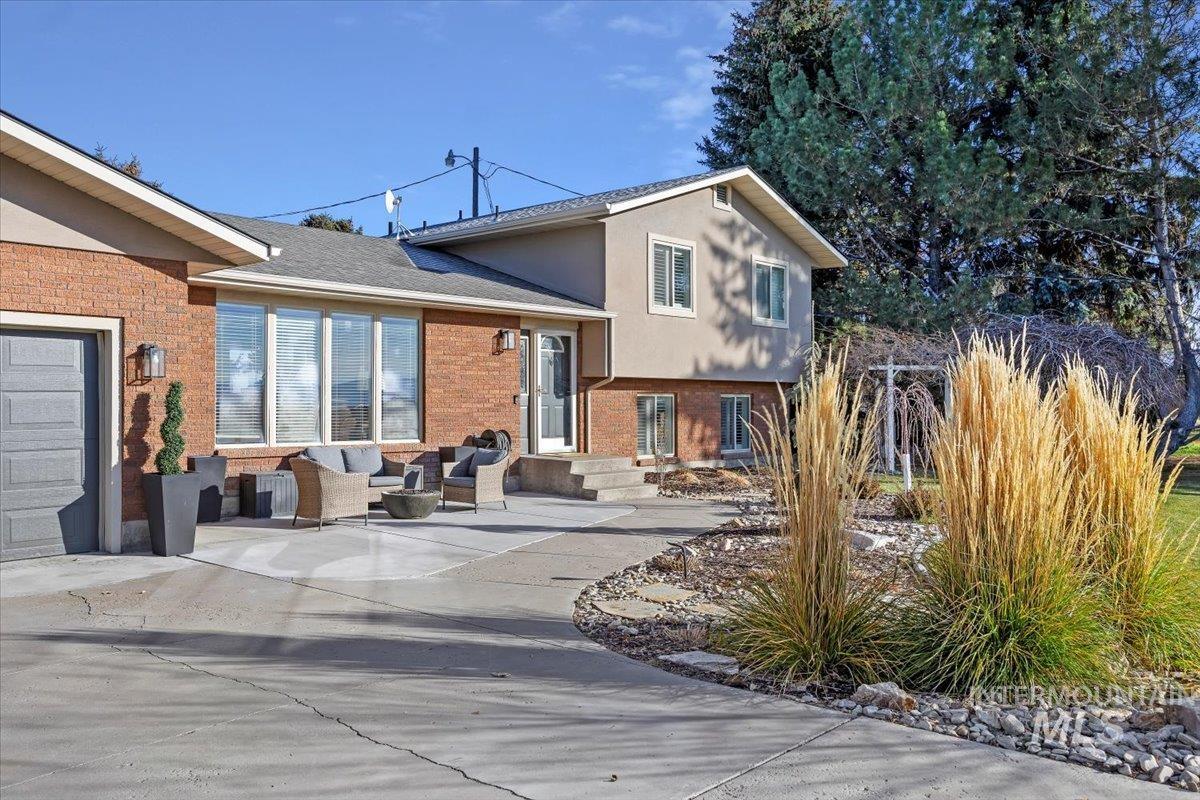 Back of property with outdoor lounge area, brick siding, and stucco siding