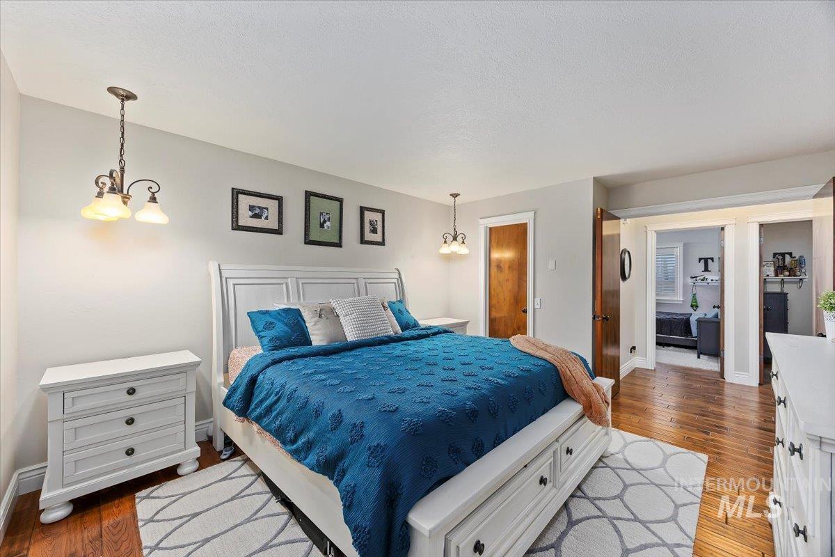 Bedroom featuring a chandelier, dark wood finished floors, and a textured ceiling