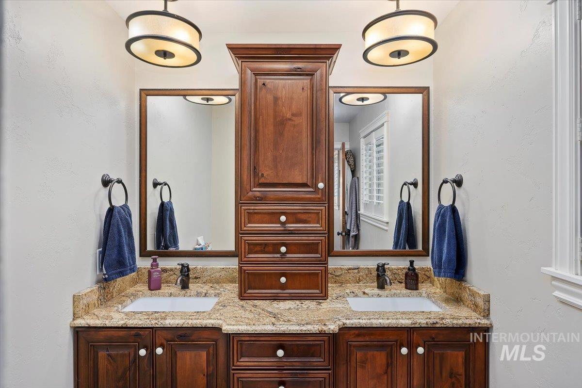 Bathroom featuring a textured wall and double vanity