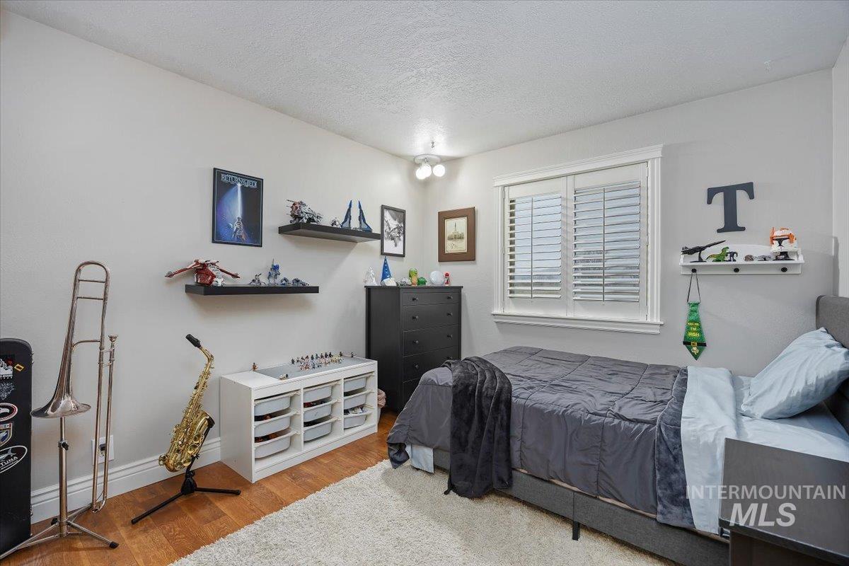 Bedroom with a textured ceiling and wood finished floors