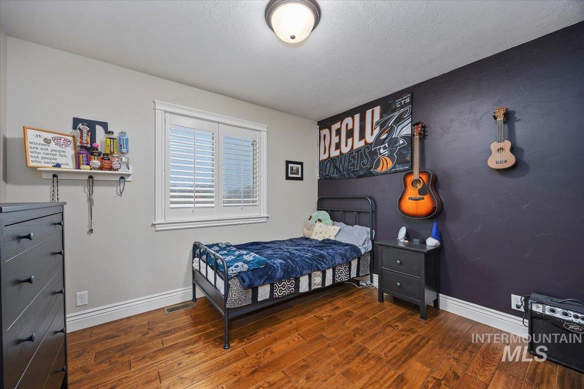 Bedroom featuring dark wood finished floors and a textured ceiling