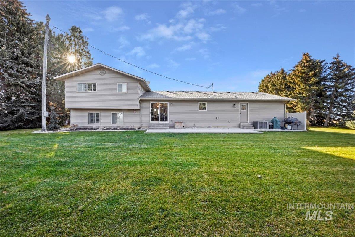 Back of property with a lawn and a patio