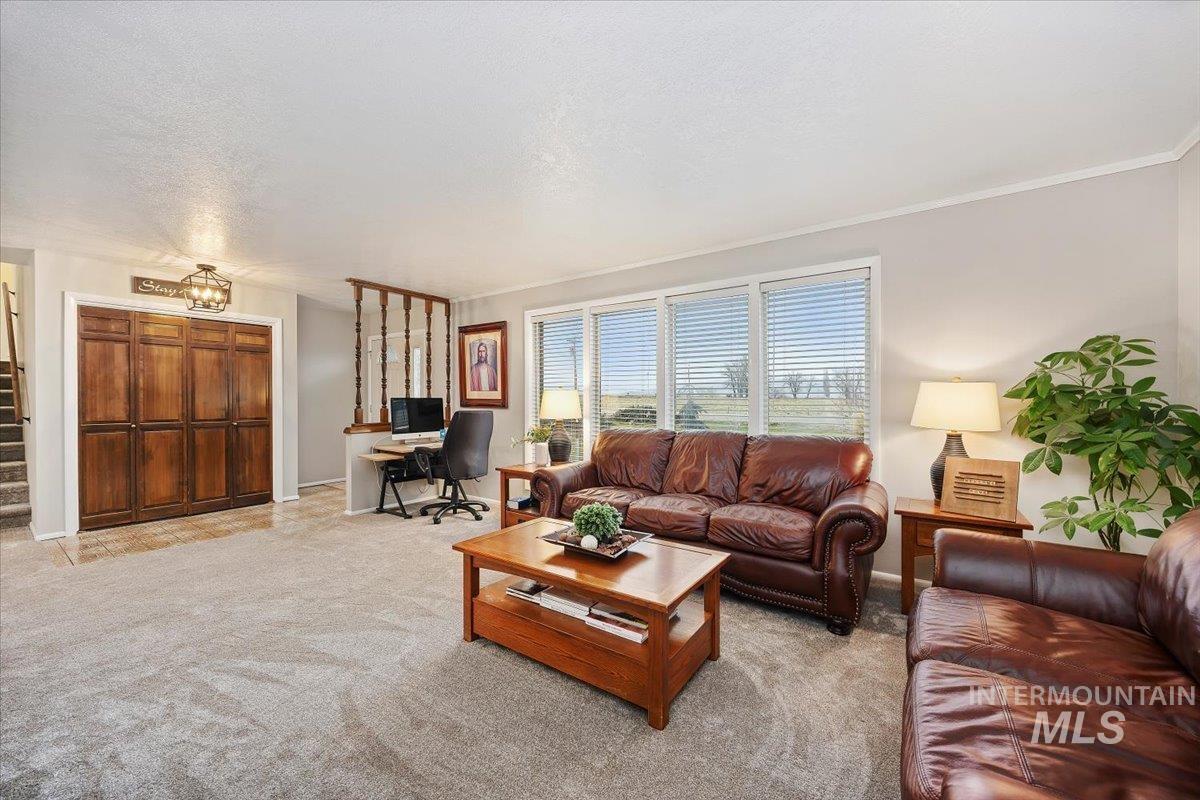 Living room featuring an office area, light carpet, and a textured ceiling
