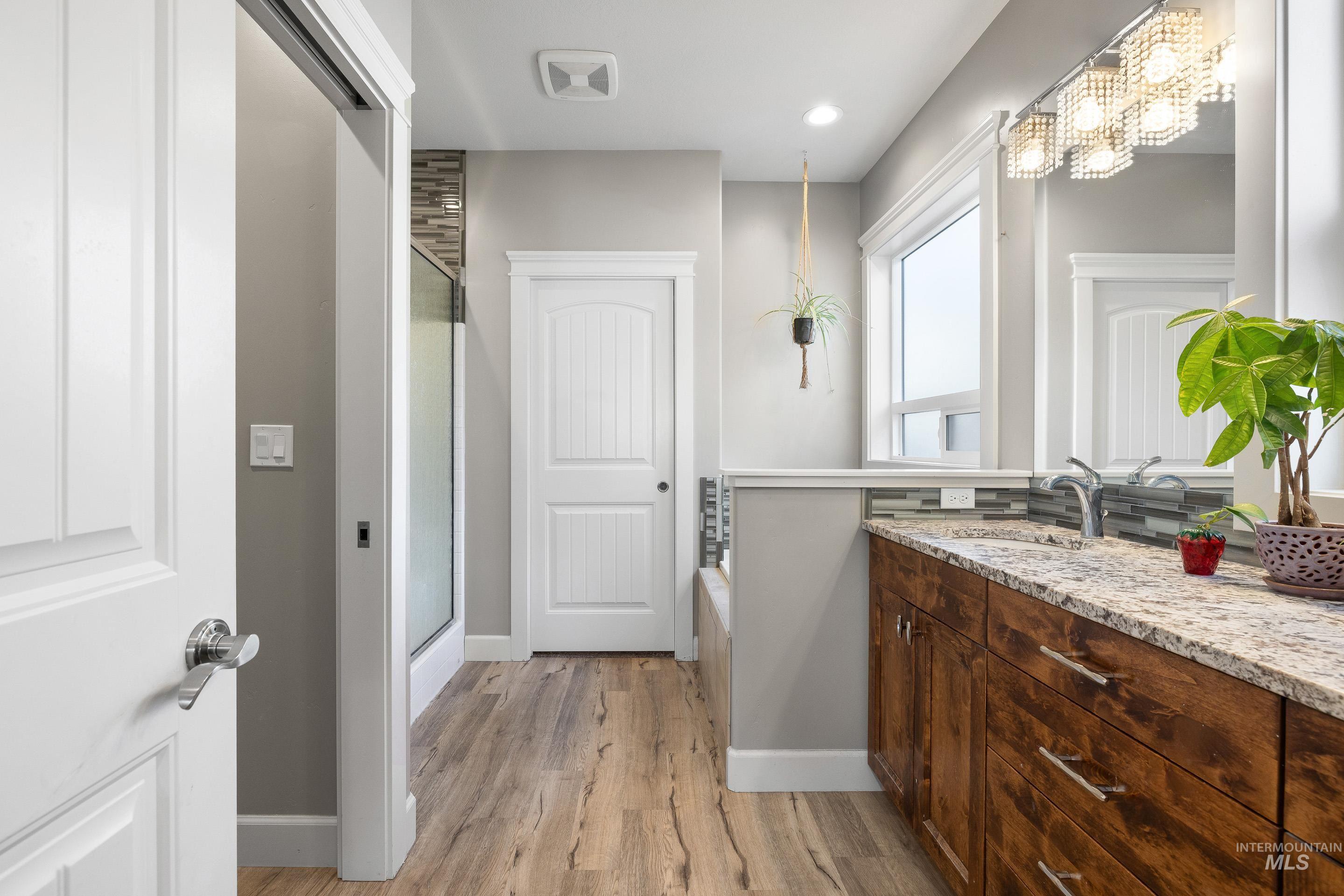 Bathroom featuring vanity, a shower stall, light wood-type flooring, and a bath